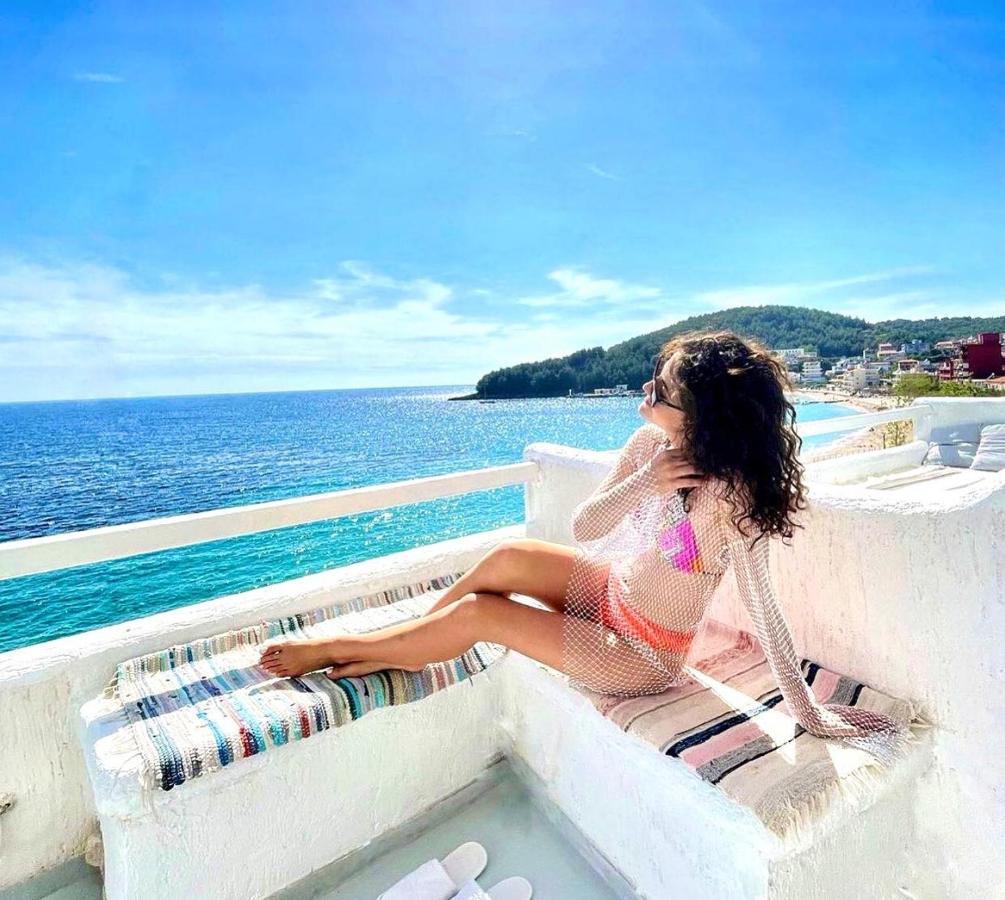 A woman relaxing on the terrace of Geo & Art boutique hotels in Himare Albania. In the background you can see the beautiful views of the sea and coastline from the hotel.