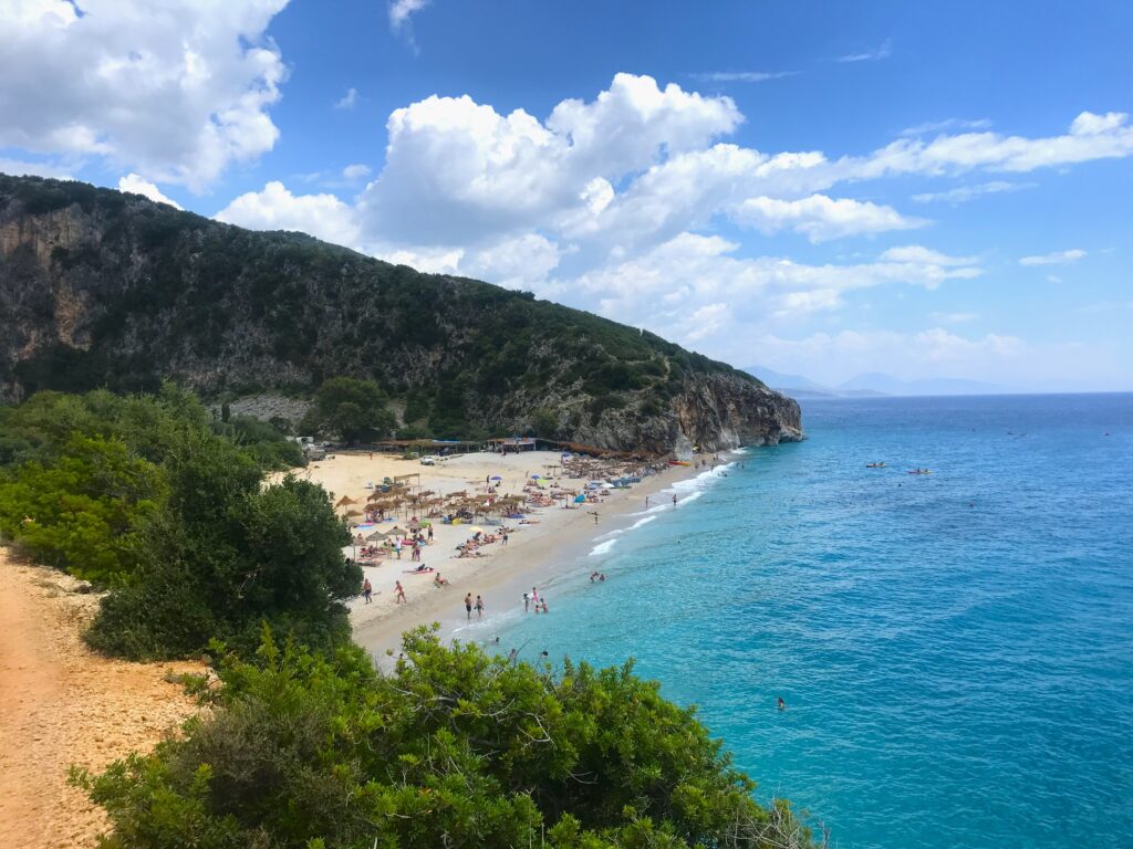 View of Gjipe beach. It is a small golden sand beach surrounded by lush green cliffs