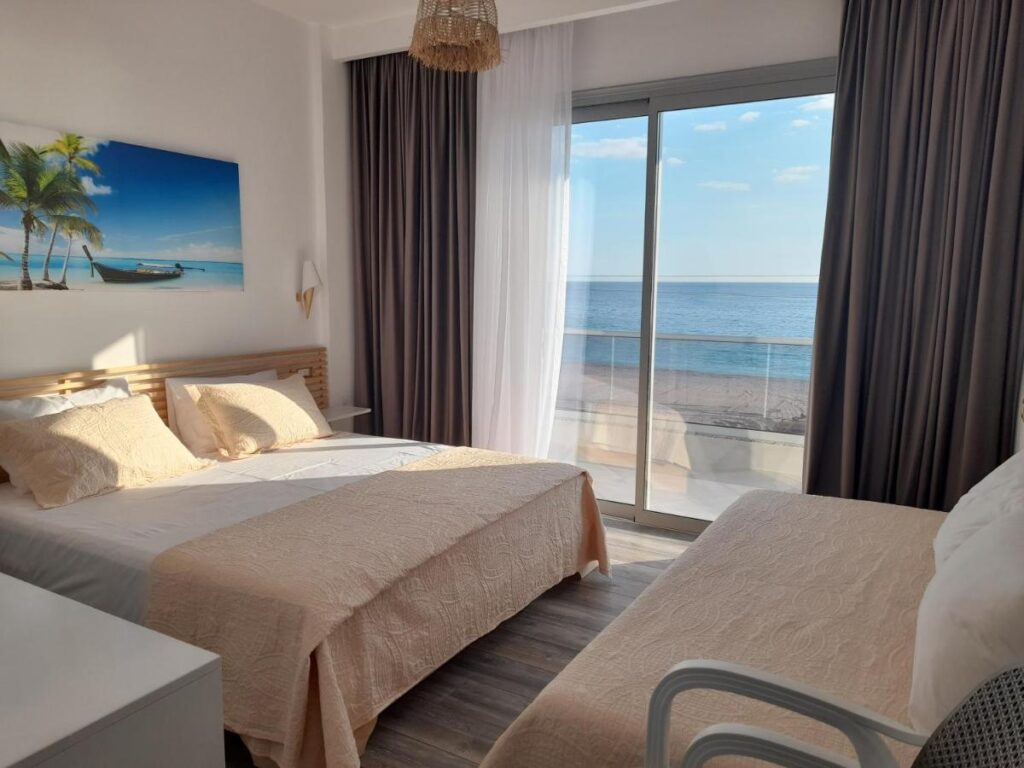 a double bedroom with seating are and balcony with sea views