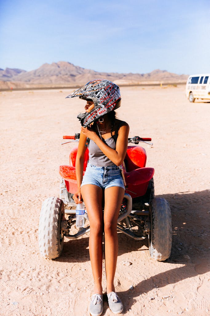 Attractvie Woman in Shorts Leaning on All Terrain Vehicle in Desert