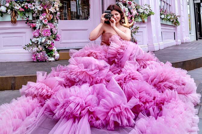women in a pink dress holding a camera outside of Peggy Porshen Cakes, one of the best London Instagram spots