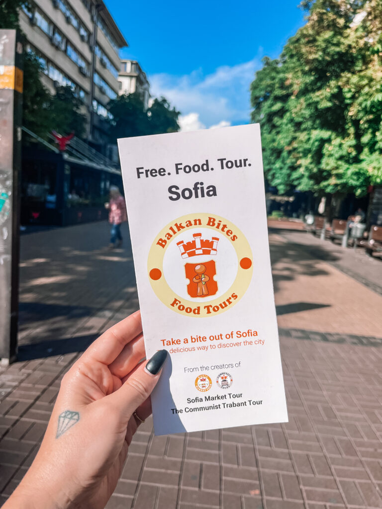 JJ's hand holding a flyer for Sofia food tours. Sofia, Bulgaria