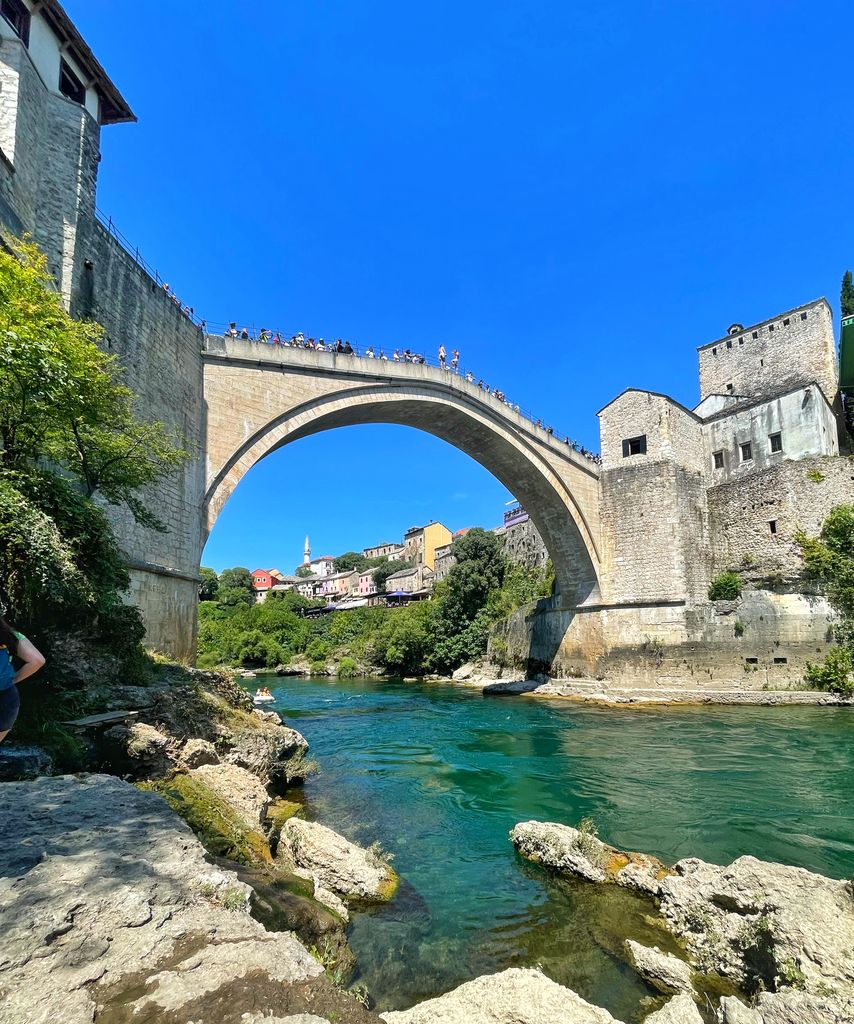 View of the historic Stari Most Bridge in Mostar, Bosnia, during a bright summer day. Bosnia instagram captions